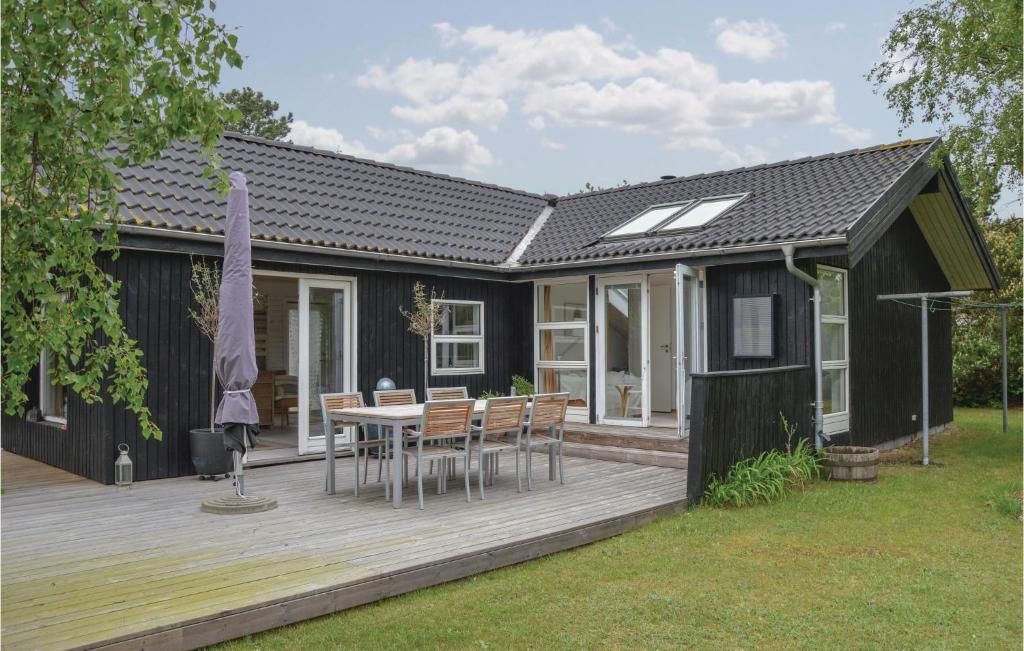 een zwart huis met een houten terras met een tafel bij Beautiful Home In Sjllands Odde With Kitchen in Yderby
