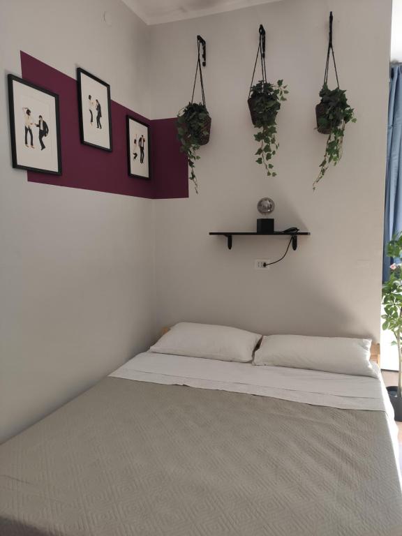 - une chambre dotée d'un lit avec des plantes sur le mur dans l'établissement Misseregram, à Naples