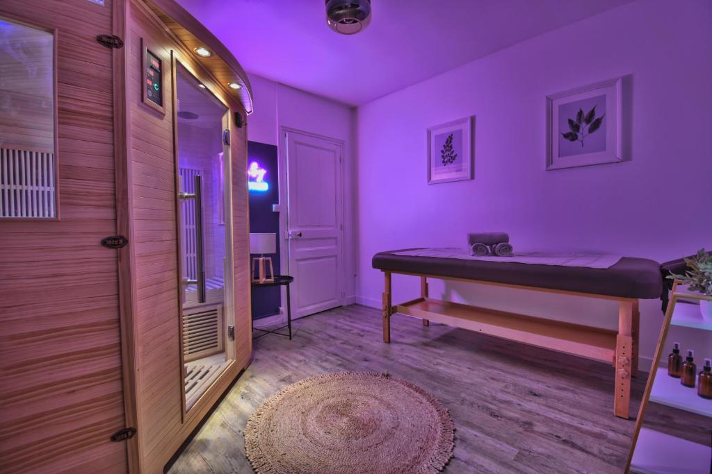 Cette chambre violette comprend un lit et un couloir. dans l'établissement *Au Sauna de Maintenon*, à Maintenon