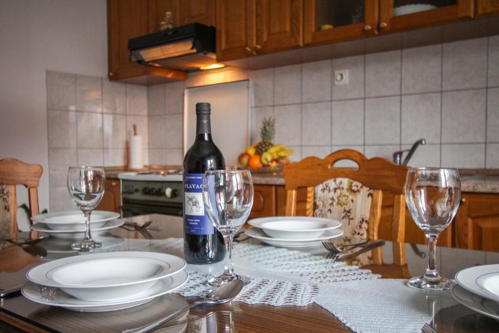 una botella de vino sentada en una mesa con copas en Apartment Cvita, en Trogir