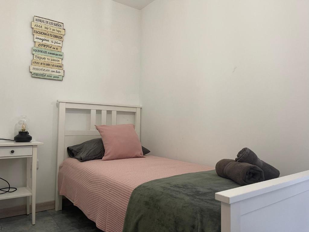 a small bedroom with a bed and a sign on the wall at Atte's house, Pozo Izquierdo in Pozo Izquierdo