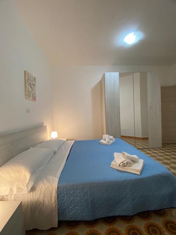- une chambre avec un grand lit et des serviettes dans l'établissement SeaView Apartments Caprioli-Palinuro, à Palinuro