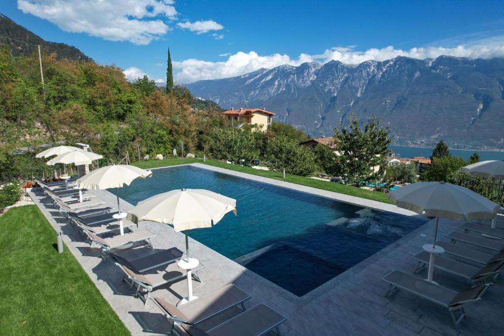 - une piscine avec des chaises longues et des parasols dans l'établissement Borgo Ermanno, à Tignale