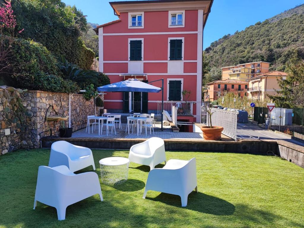 una casa con un prato con sedie e ombrellone di LA POMELLA a Portovenere