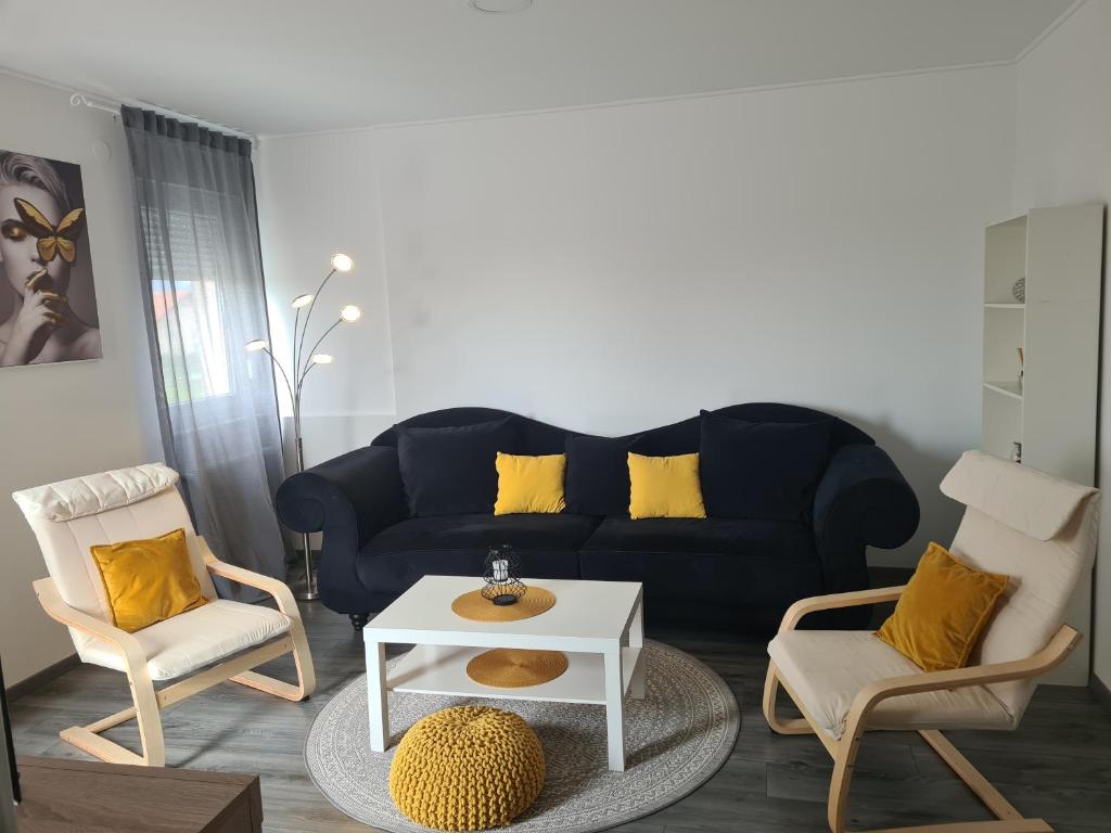 uma sala de estar com um sofá azul e duas cadeiras em Apartman Lea em Kraljevec Sesvetski