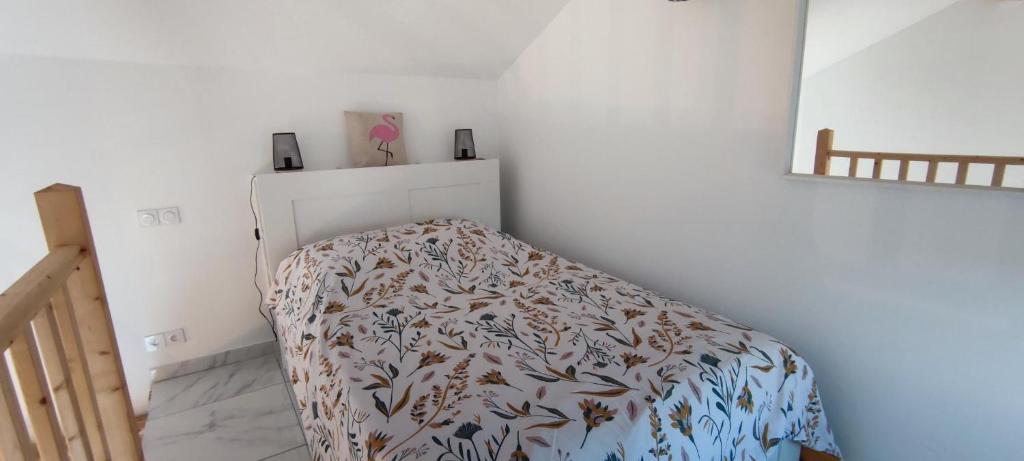 een slaapkamer met een bed met een deken erop bij Appartement au coeur des rizières in Salin-de-Giraud