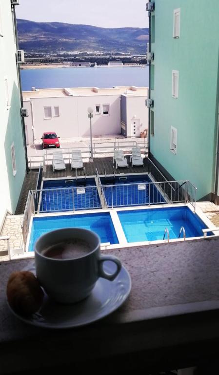 a cup of coffee on a table with a view of a pool at Apartment Iva in Trogir