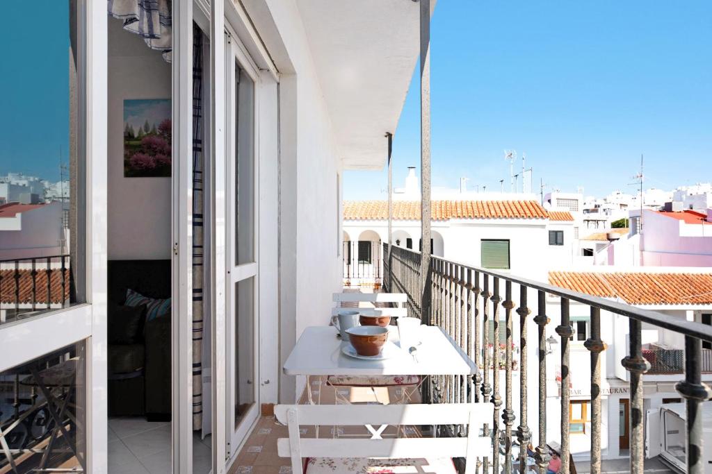 a balcony with a table and a view of the city at Apartamento Mercedes in Conil de la Frontera