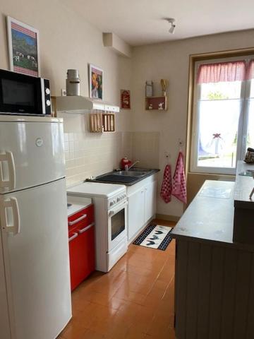 a kitchen with a white refrigerator and a sink at Le Moulin du Modon in Couffy