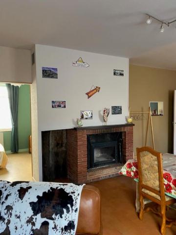 a living room with a fireplace with pictures on the wall at Le Moulin du Modon in Couffy