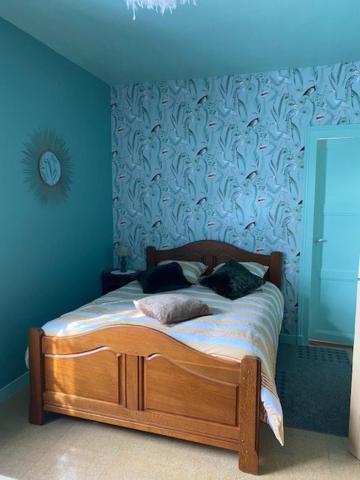 a bedroom with a bed with a blue wall at Le Moulin du Modon in Couffy