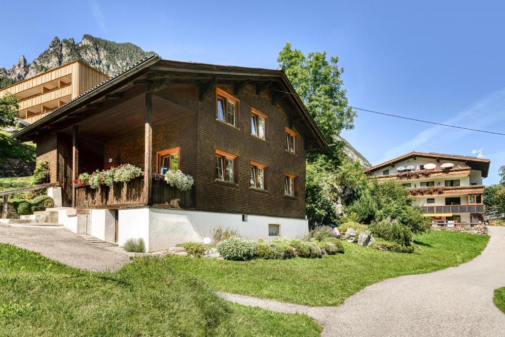 une maison dans les montagnes avec un chemin menant à celle-ci dans l'établissement Walserhaus, à Brand