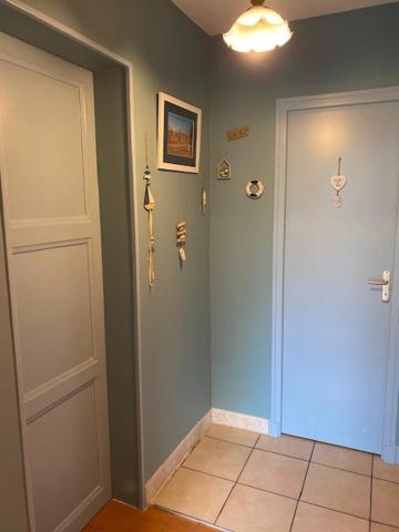 a hallway with a white door and a tile floor at Le Moulin du Modon in Couffy