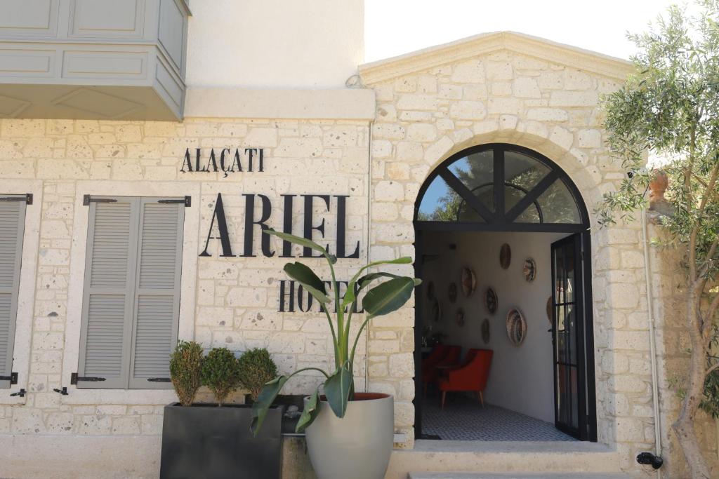 Ariel Hotel Alaçatı في ألاتشاتي: مبنى امامه باب ومصنع