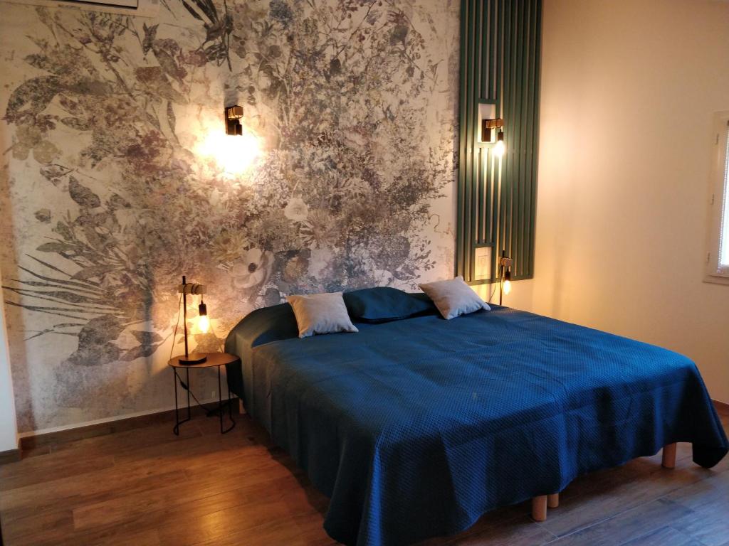 a bedroom with a blue bed and a wall mural at Casa voscia in Casalabriva