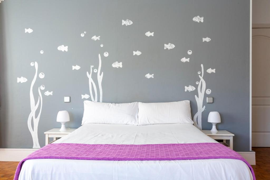 1 dormitorio con 1 cama con sábanas moradas y ramas blancas en Monrooms Barcelona, en Barcelona