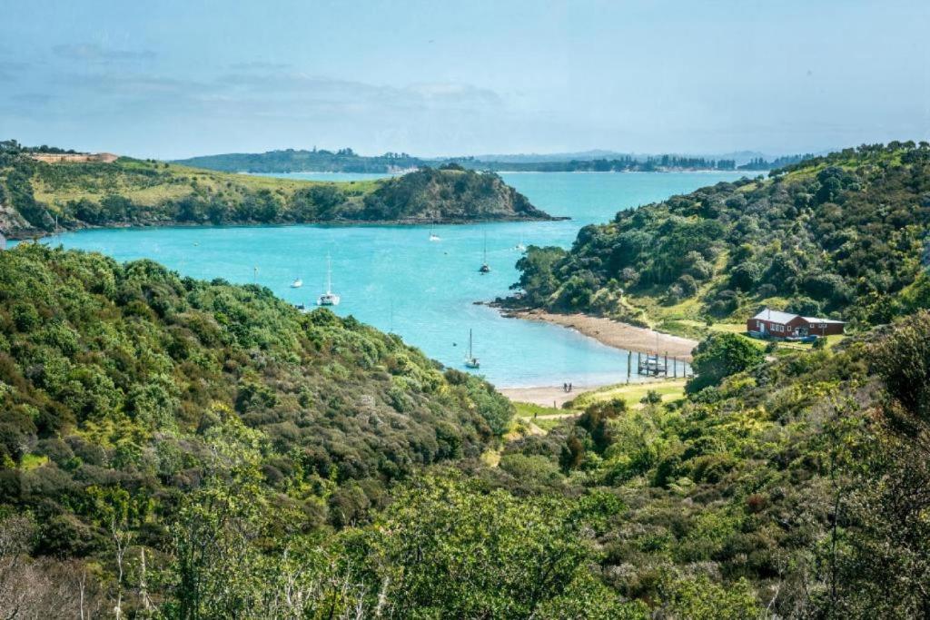 a view of a beach with boats in the water at Delamore Cove - Kowhai - Waiheke Escapes in Matiatia Bay