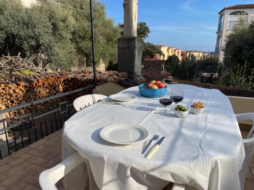 una mesa blanca con copas de vino en el balcón en Da Mamma IUN Q9152, en Santa Maria Navarrese