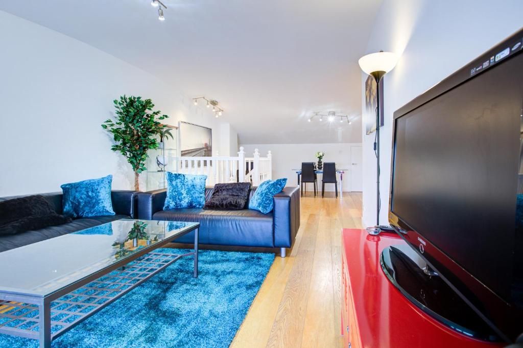 a living room with a couch and a tv at Statera Apartments - Thames View in London