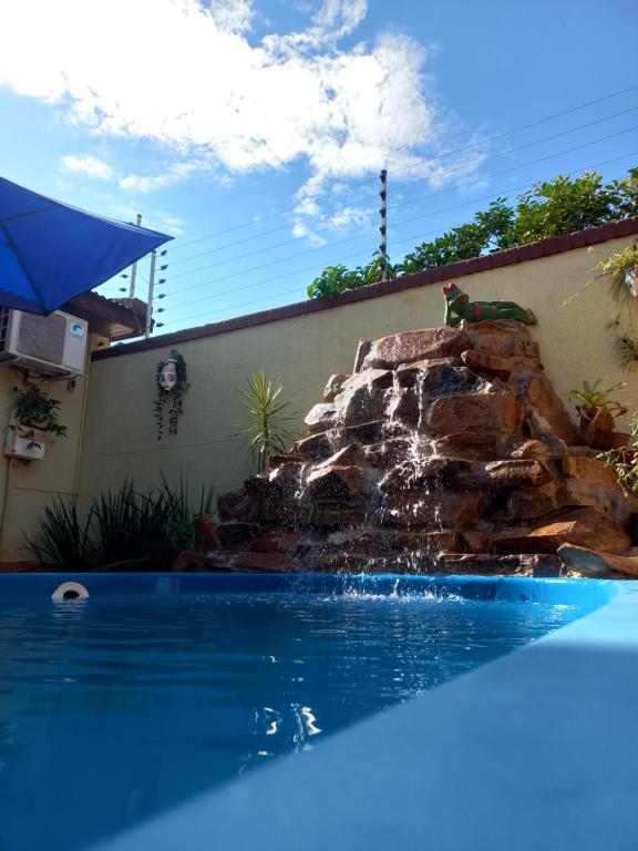 a swimming pool with a waterfall in a yard at Salto dos hermanas in Puerto Iguazú