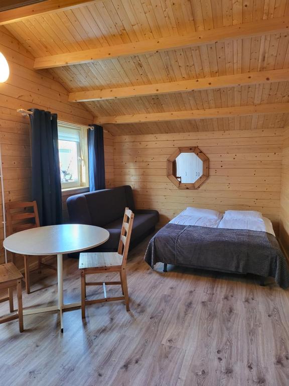 - une chambre avec un lit, une table et un canapé dans l'établissement Siodemkacamp Karwia, à Karwia