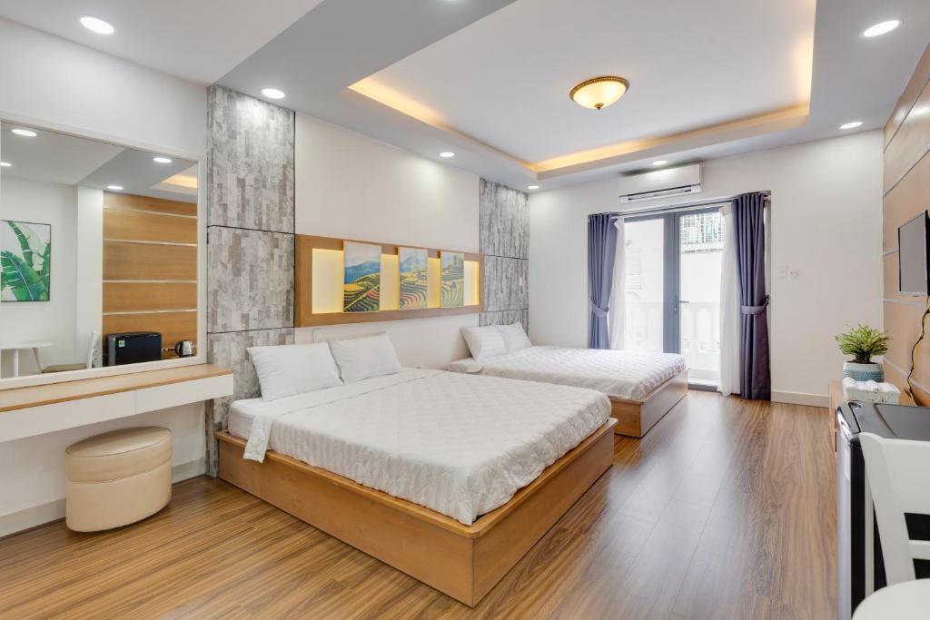 a hotel room with two beds and a television at Saigon Authentic Hostel - Cozy Rooftop, Family Cooking Experience, FREE Walking Tour, Vietnamese Breakfast & Gym in Ho Chi Minh City