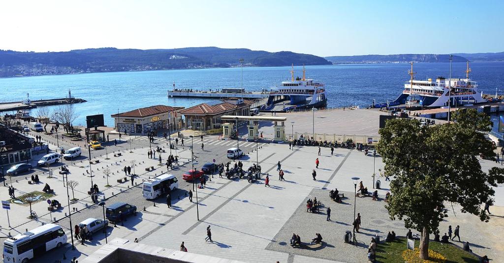 un grupo de personas caminando por un puerto con barcos en Parion House Hotel en Çanakkale