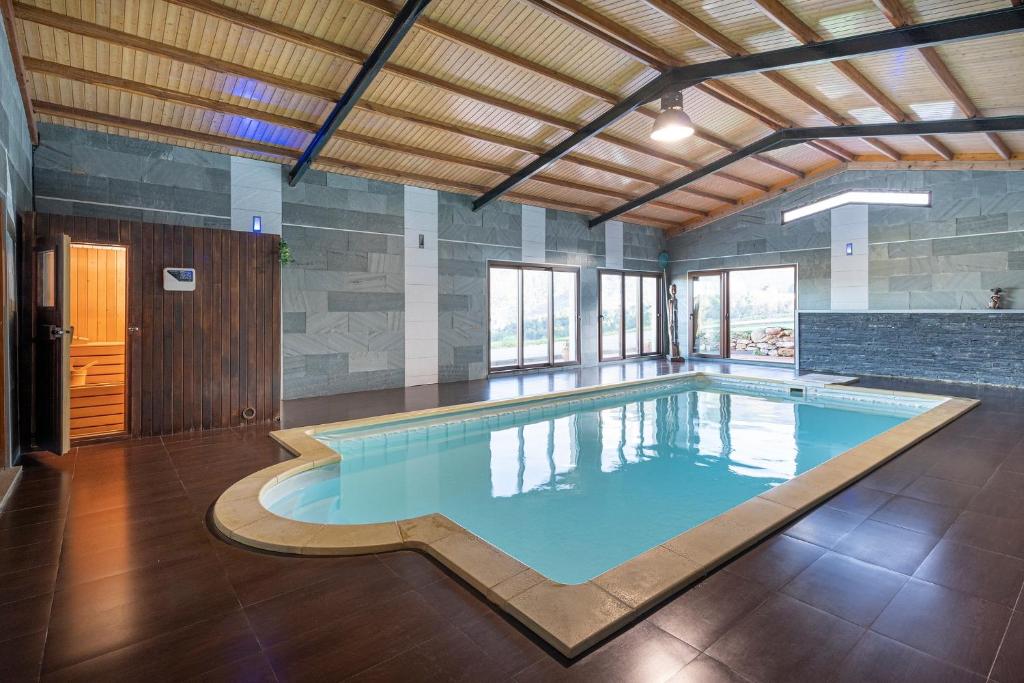 a large swimming pool in a large room with at Luxury Valdeorras in Valdegodos