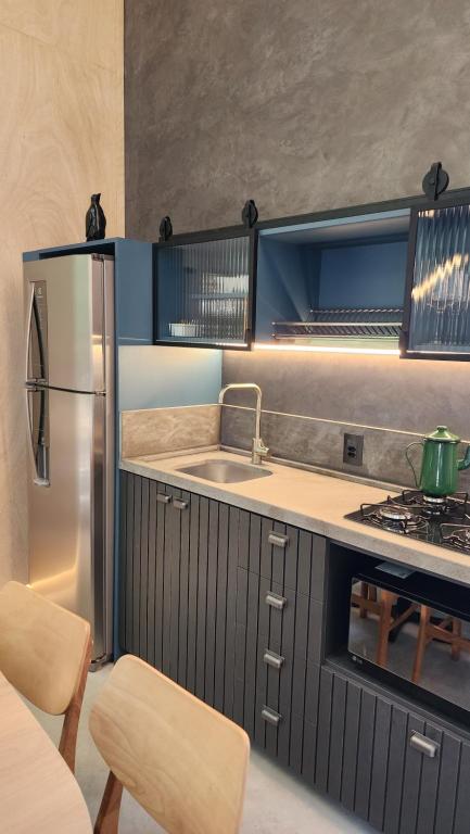 a kitchen with a stainless steel refrigerator and a sink at Arau Cabana Cheiro de Mato in Flores da Cunha