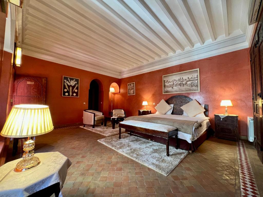 a bedroom with a bed and a table with a lamp at Riad Sassa Finda in Marrakesh