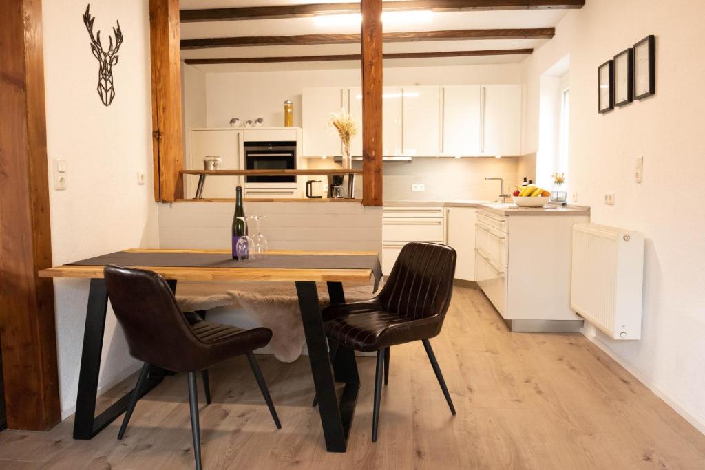 a kitchen with a wooden table and chairs in a room at Rhön & Relax in Wildflecken