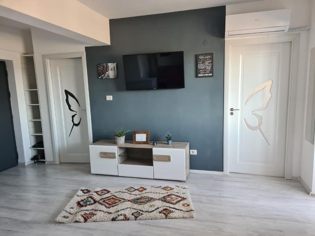 a living room with a tv and a white cabinet at Mall Q4 Apartments in Bacău