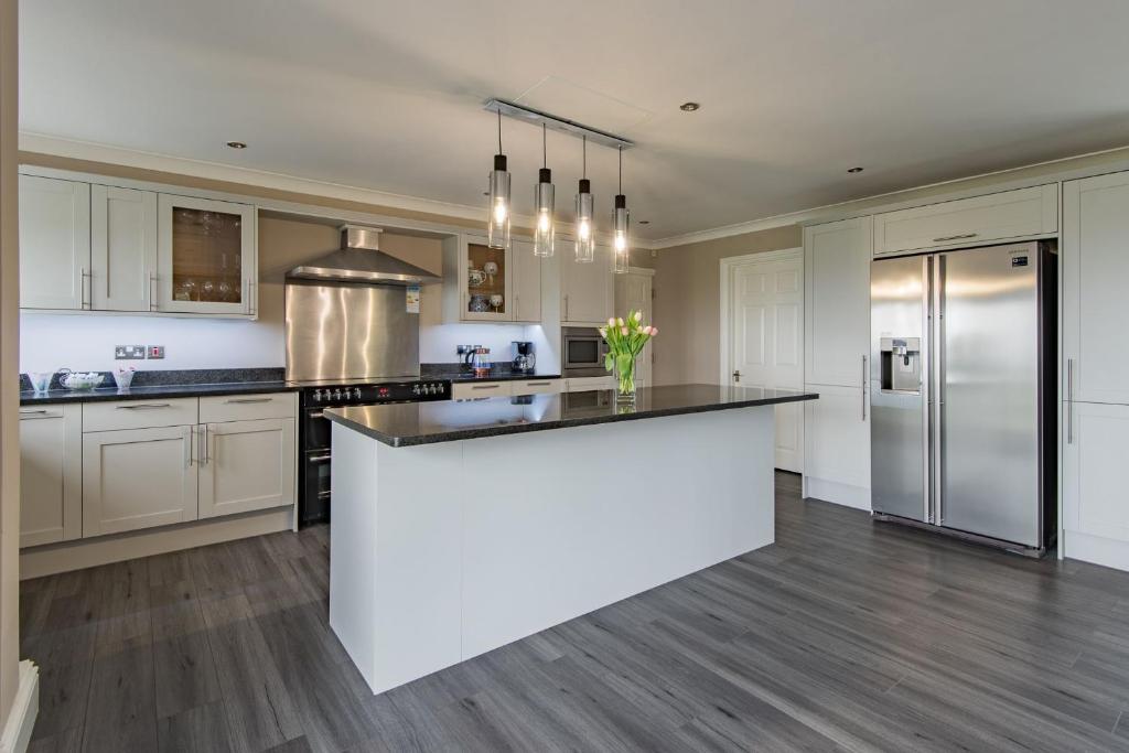 a kitchen with white cabinets and a large white island at The Homestead by Bloom Stays in Canterbury