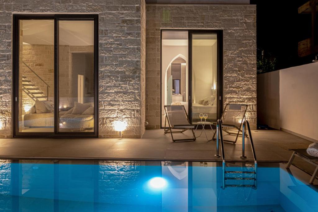 a house with a swimming pool at night at Perla Dream Luxury Villa in Chania Town