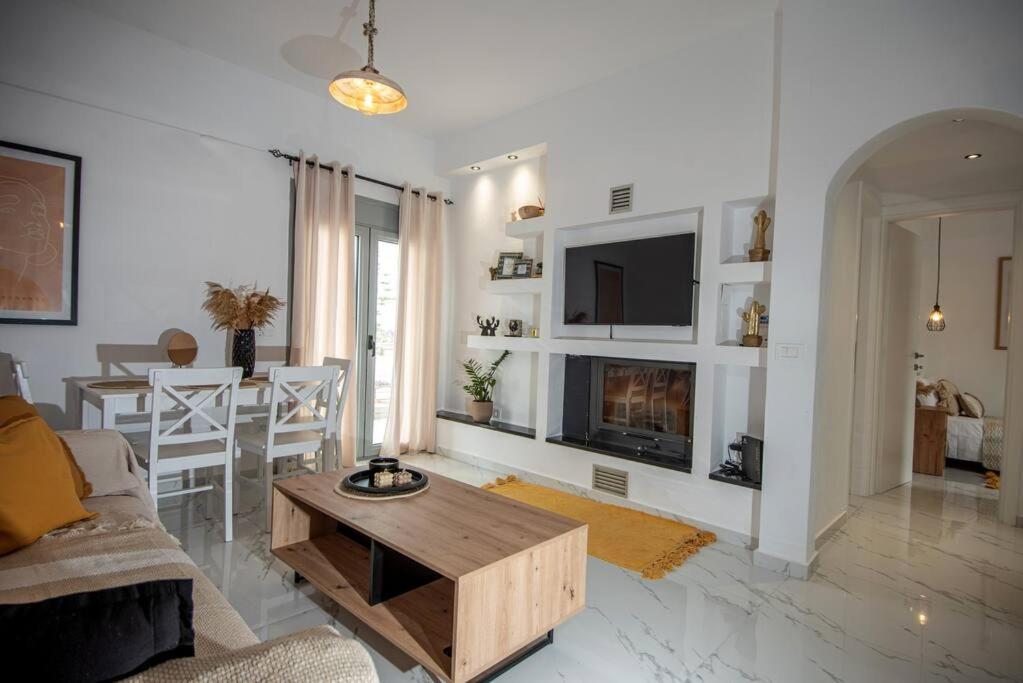 Μοντέρνο διαμέρισμα ALMYRA في آغيوس نيكولاوس: غرفة معيشة مع أريكة وطاولة قهوة