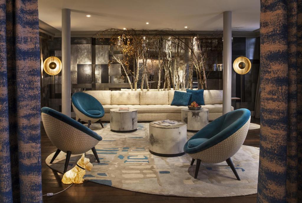 a living room with two chairs and a couch at Hôtel Thérèse in Paris