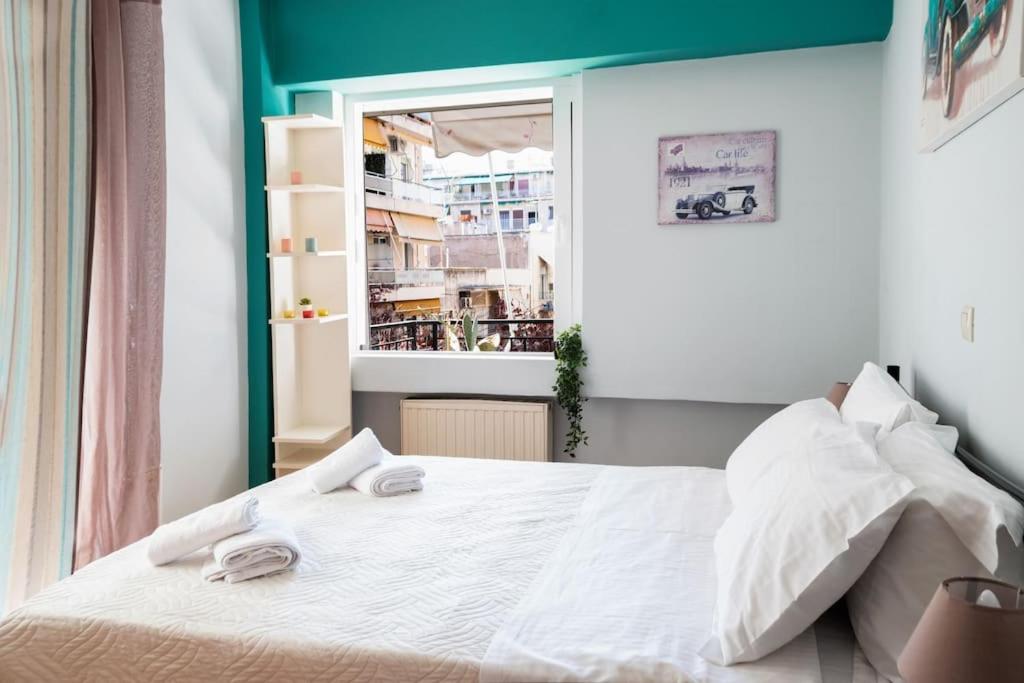 - une chambre avec un lit blanc et une fenêtre dans l'établissement Apartment in Athens, Pagrati, à Athènes