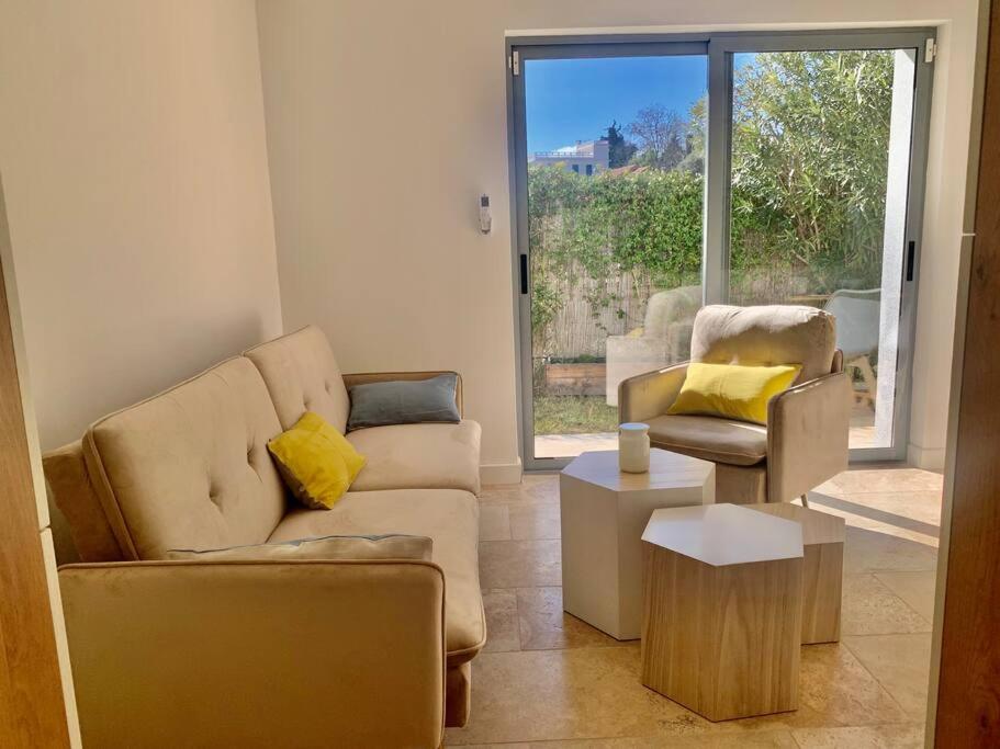 un salon avec un canapé et deux chaises dans l'établissement La Reposée, bas de villa en plein cœur de Vence, à Vence