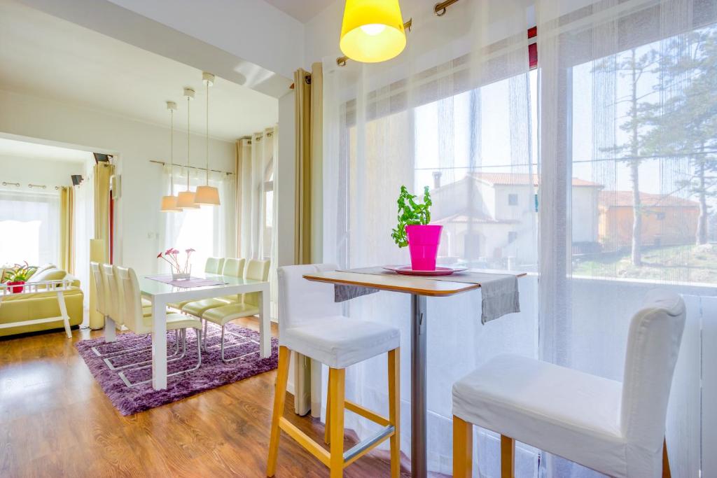 eine Küche und ein Esszimmer mit einem Tisch und Stühlen in der Unterkunft Cozy and Modern Apartments in Kastav