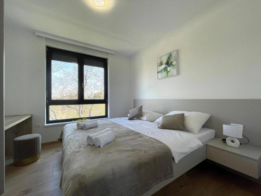 梅杜林Apartman Moonlight Medulin的一间卧室，配有一张大床和一扇窗户。