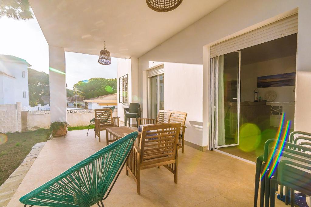 a patio with chairs and a table and a window at Chalet individual en el Rompido urb Urverosa in El Rompido