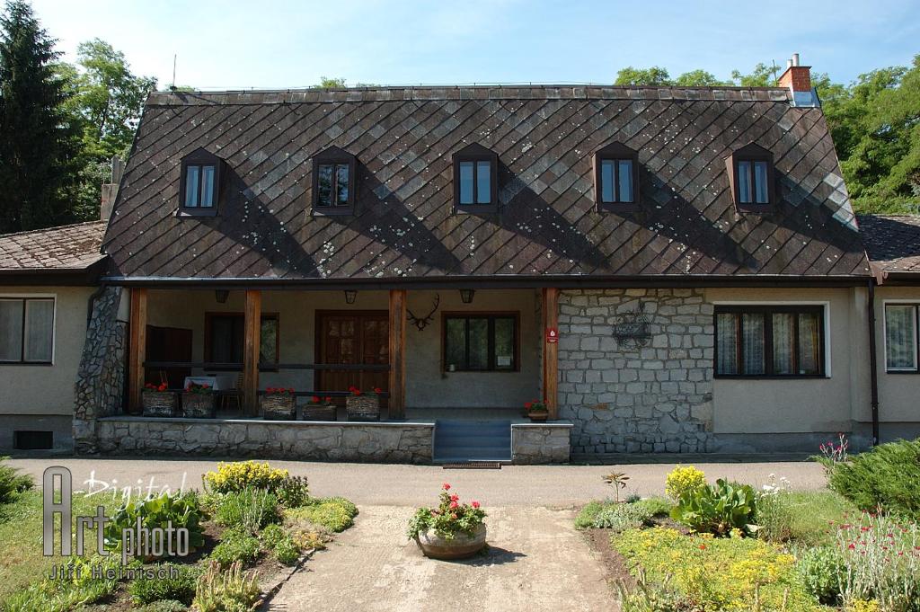 ein Haus mit einem gefliesten Dach und einem Innenhof in der Unterkunft Lovecká chata Myslivna in Hrušovany nad Jevišovkou