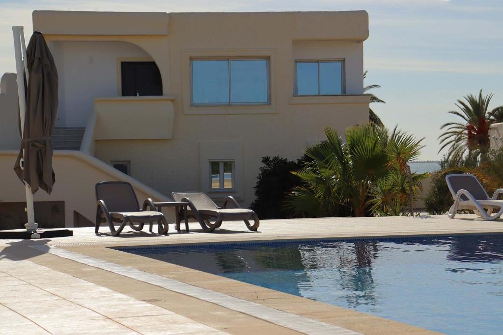 uma casa com piscina em frente a uma casa em Villa Luna Domaine Béluga Bounouma kerkennah em Sfax
