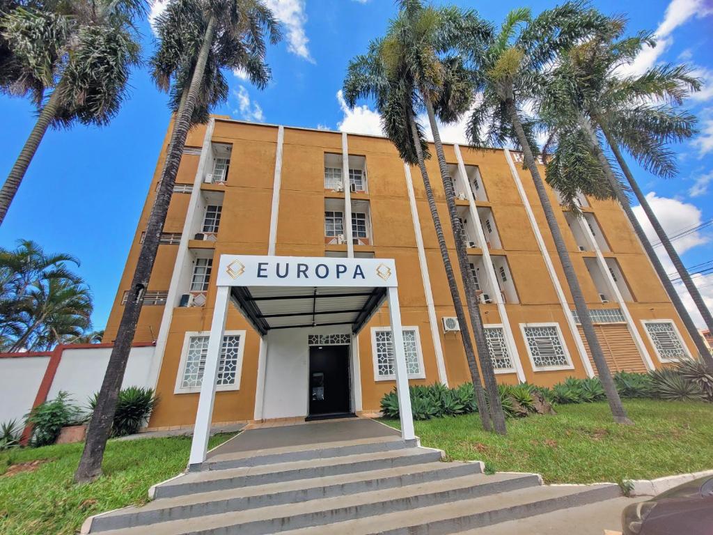 um edifício com palmeiras em frente em Europa Hotel Brasília em Taguatinga