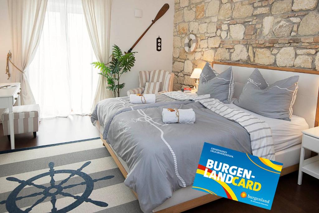 a bedroom with a large bed with a book on it at Captain's Suite in Neusiedl am See