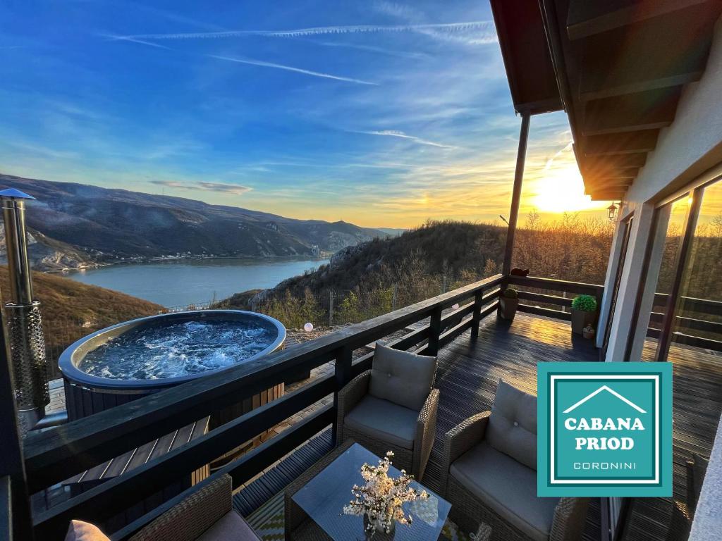 a balcony with a tub and a view of a lake at Cabana Priod Coronini in Pescari