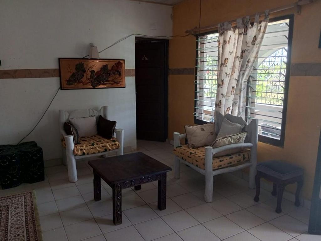 a living room with two chairs and a table at Fred Hunter Villa in Tiwi