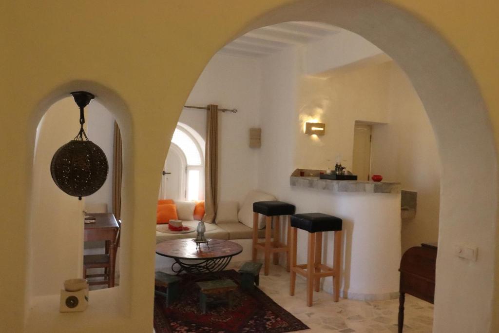 sala de estar con arco, mesa y sillas en Suite Vesta Villa Naïa Domaine Béluga Bounouma Kerkennah, en Sfax