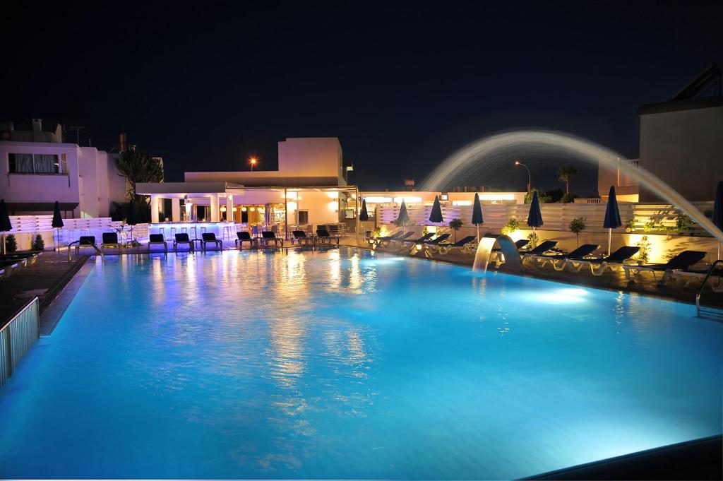 a large swimming pool at night with chairs and umbrellas at Euronapa Hotel Apartments in Ayia Napa