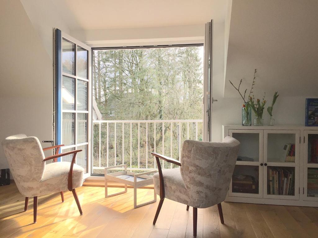 a living room with two chairs and a large window at Ferienwohnung "Wasserburg" in Ascheffel